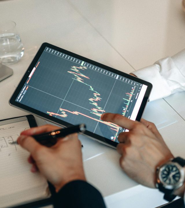 Team working on financial analysis using tablet and calculator in office.