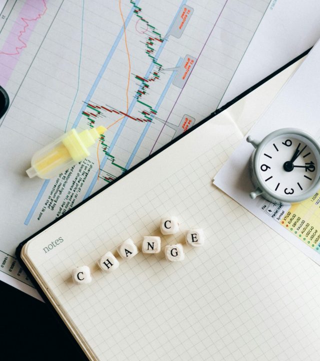 Top view of financial documents with charts, calculator, clock, and the word 'Change' in focus.